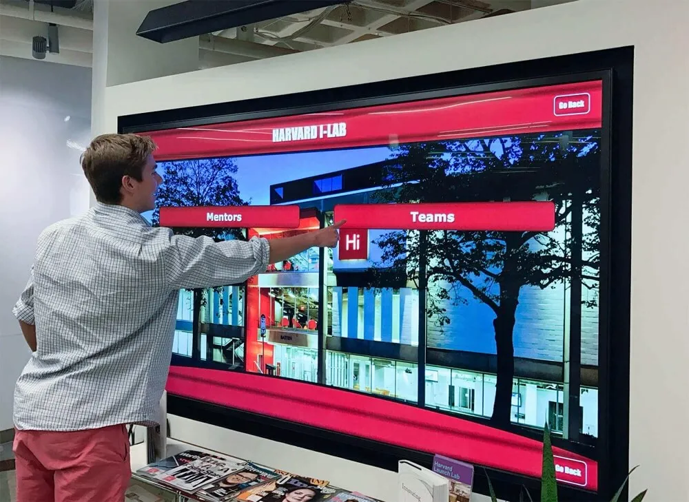 Person interacting with touchscreen display showing mentors and programs