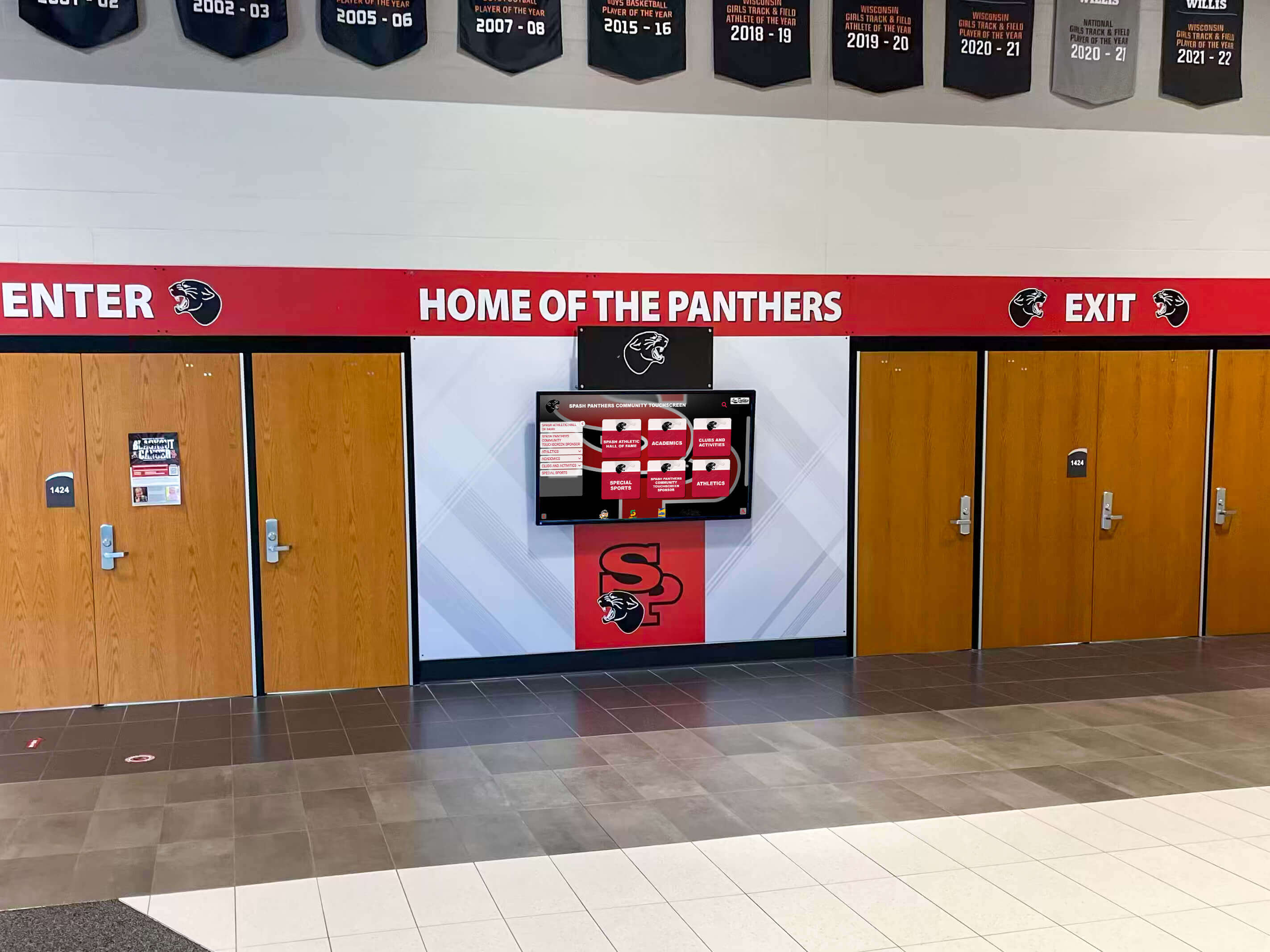 School entrance featuring Home of the Panthers signage alongside a digital display screen for recognition and announcements School hall of the Panthers entrance with digital display screen