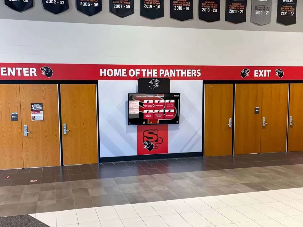 School hallway digital display screen beside wooden entrance doors — the multi-field report queries that populate recognition displays like this one require accurate row estimates from the database planner to execute efficiently School hallway with “Home of the Panthers” digital screen beside wooden entrance doors